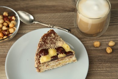 Photo of Piece of delicious Kyiv Cake served with coffee on wooden table, selective focus
