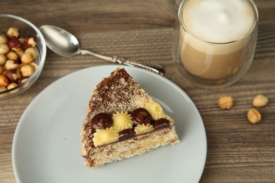 Piece of delicious Kyiv Cake served with coffee on wooden table, selective focus