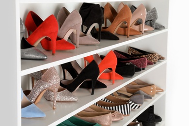 Photo of Shelving unit with different shoes. Element of dressing room interior
