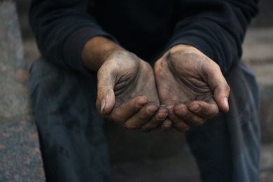 Poor homeless man begging for help outdoors, closeup