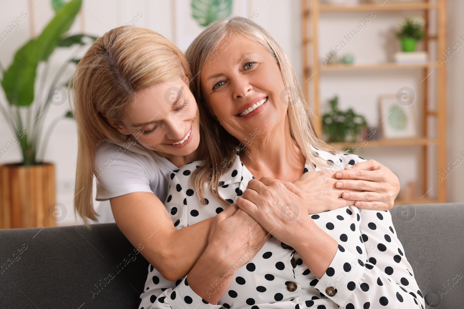 Photo of Happy mature mother and her daughter hugging at home