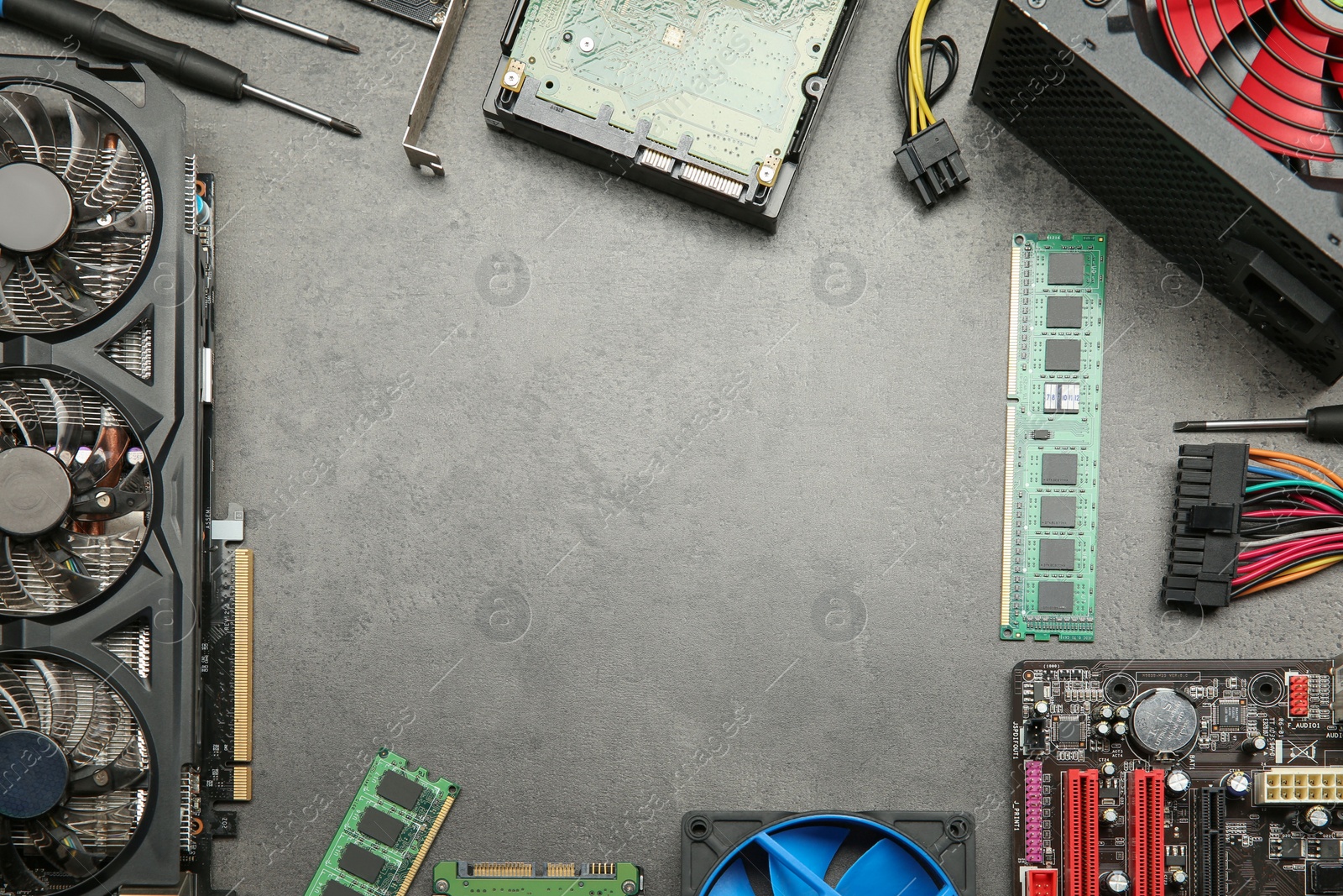 Photo of Frame of graphics card and other computer hardware on grey textured table, flat lay. Space for text