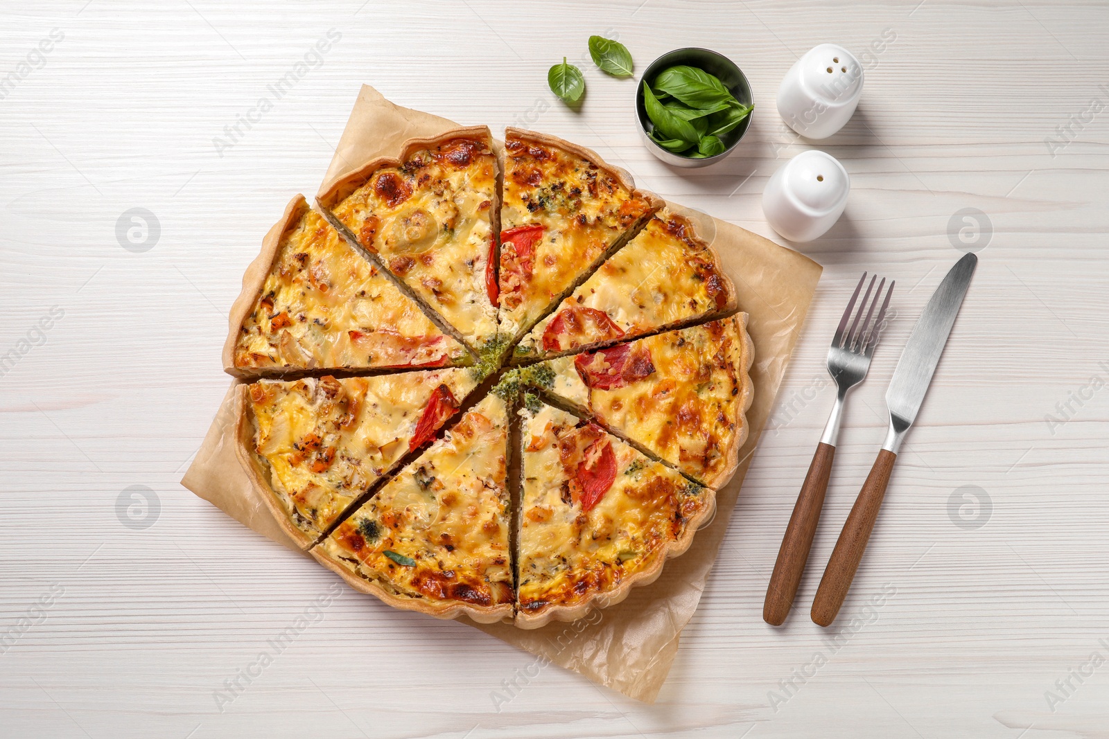 Photo of Tasty quiche with tomatoes and cheese served on white wooden table, flat lay