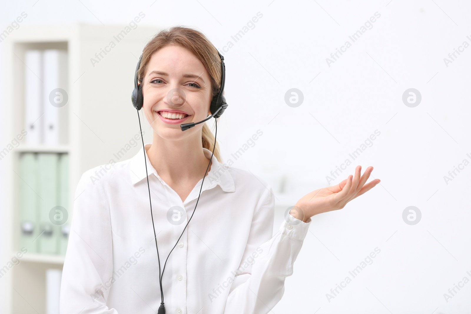 Photo of Young female receptionist with headset in office