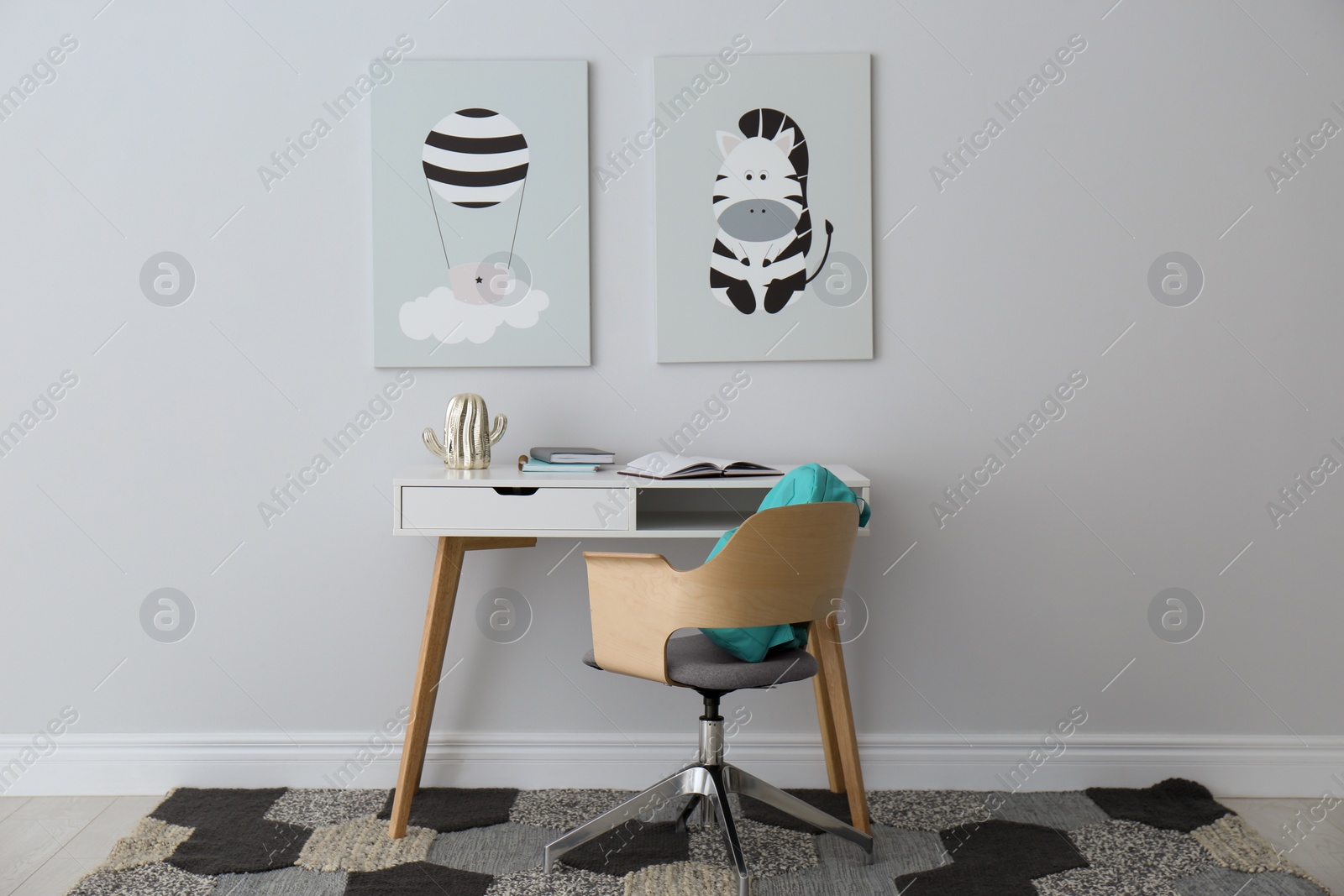 Photo of Child's room interior with desk and cute posters on light wall