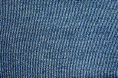 Photo of Texture of blue jeans as background, closeup