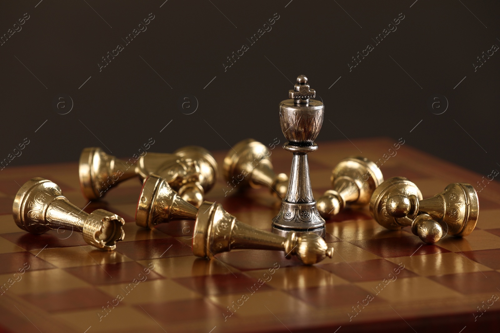 Photo of Chessboard with game pieces on dark background, closeup