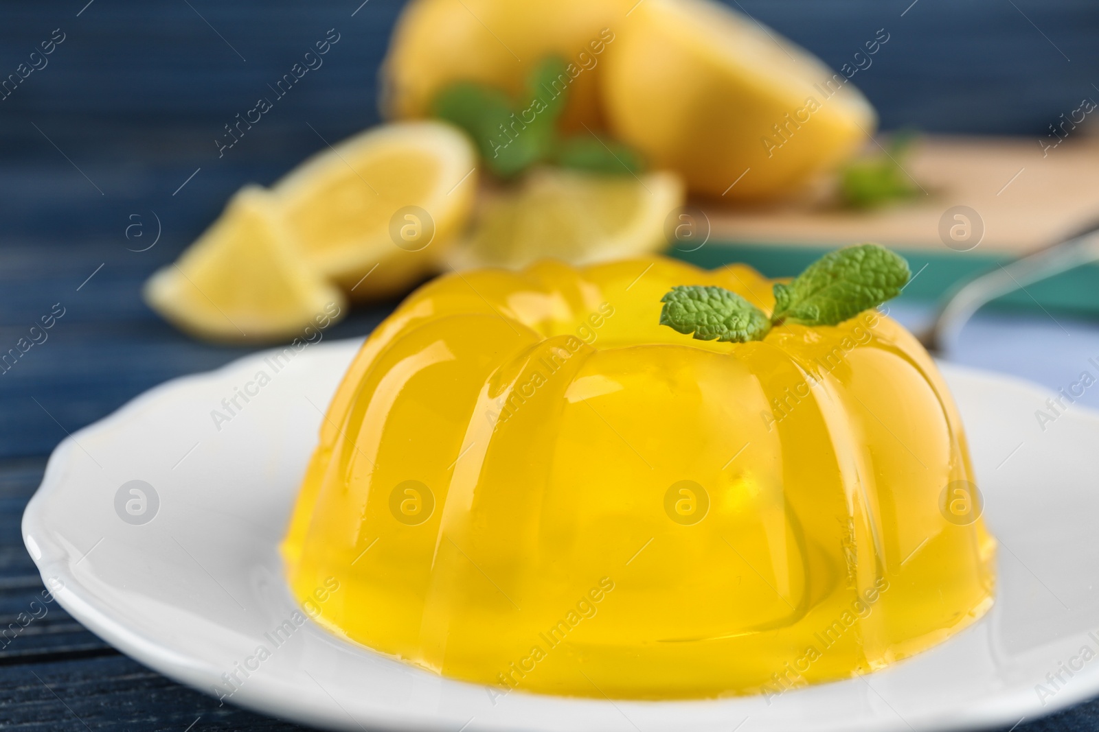Photo of Plate with lemon jelly and mint on wooden table, closeup