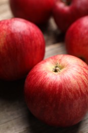 Photo of Fresh red apples on wooden table, closeup