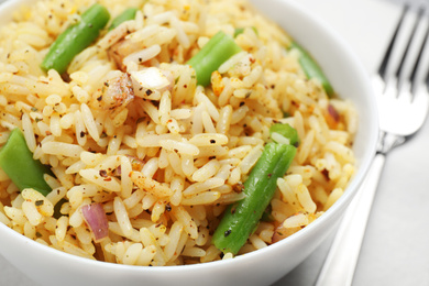 Photo of Tasty rice pilaf with vegetables on table, closeup