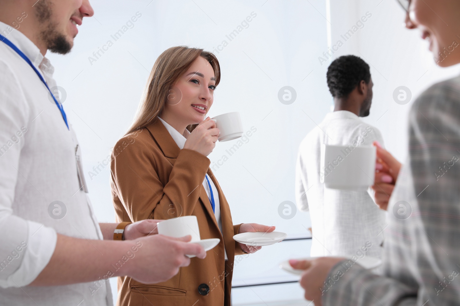 Photo of Group of people chatting during coffee break indoors