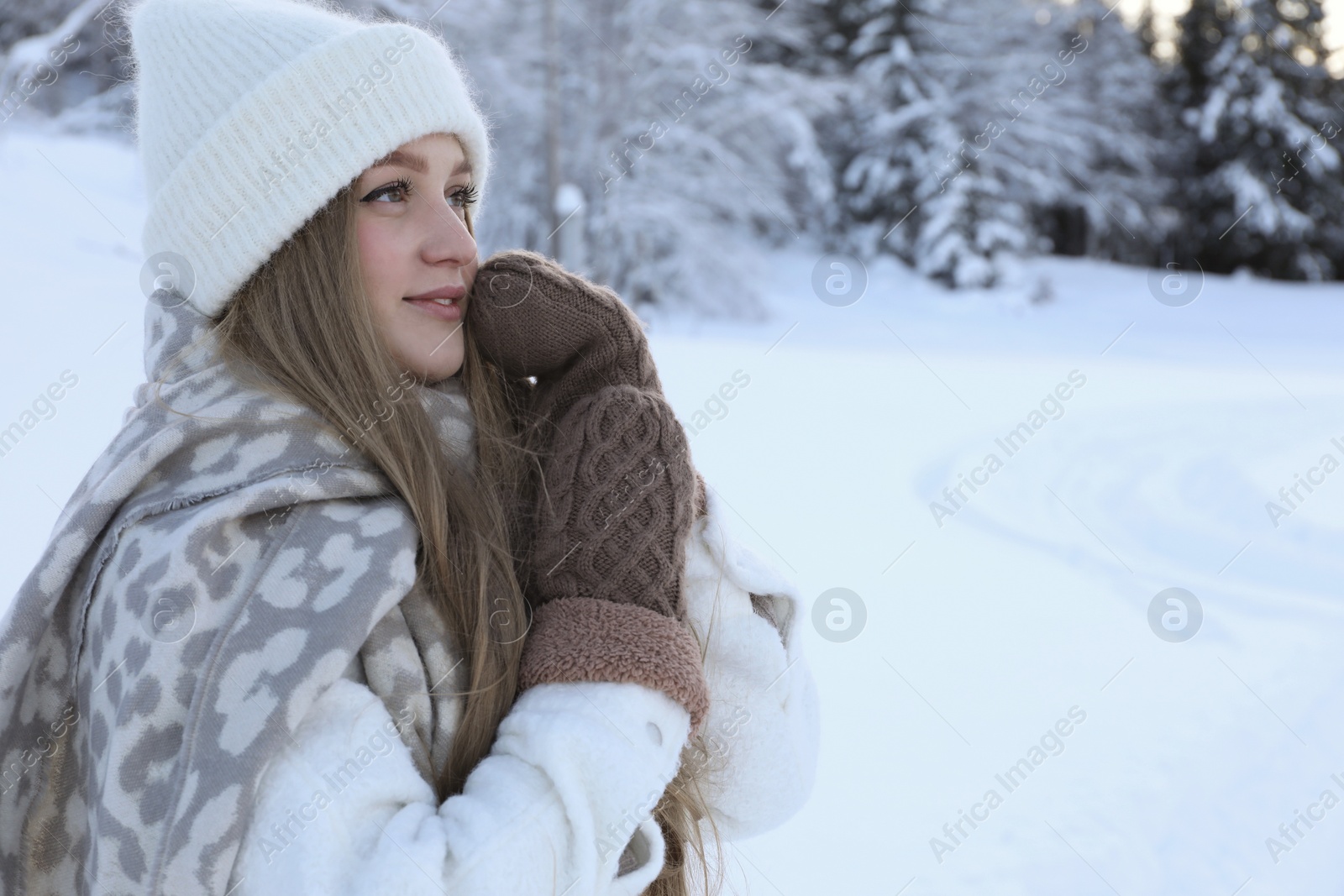 Photo of Winter vacation. Beautiful woman near snowy forest outdoors. Space for text