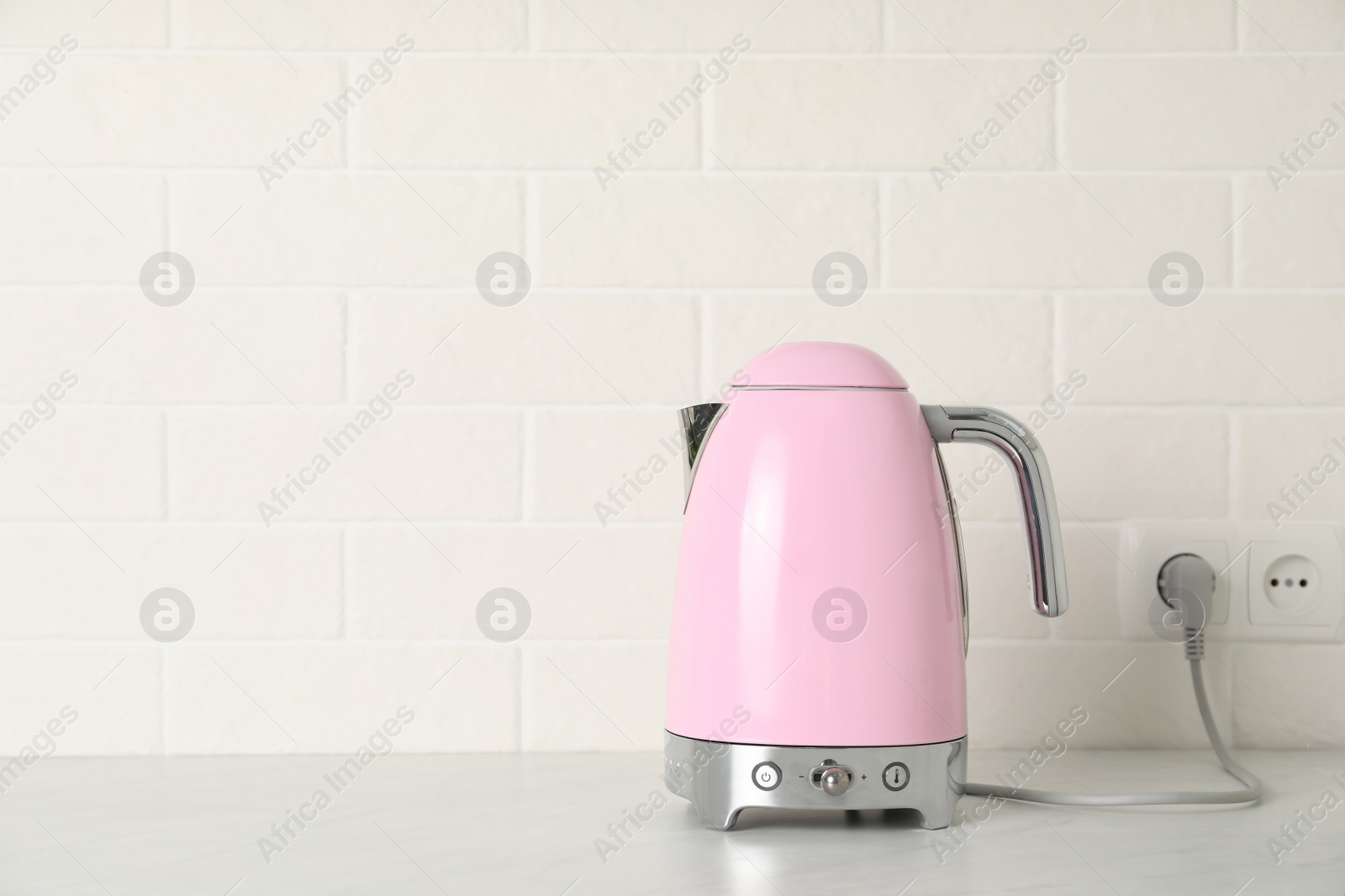 Photo of Modern electric kettle on counter in kitchen. Space for text