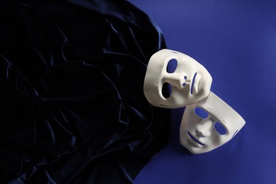 Theater arts. White masks and fabric on blue background, top view