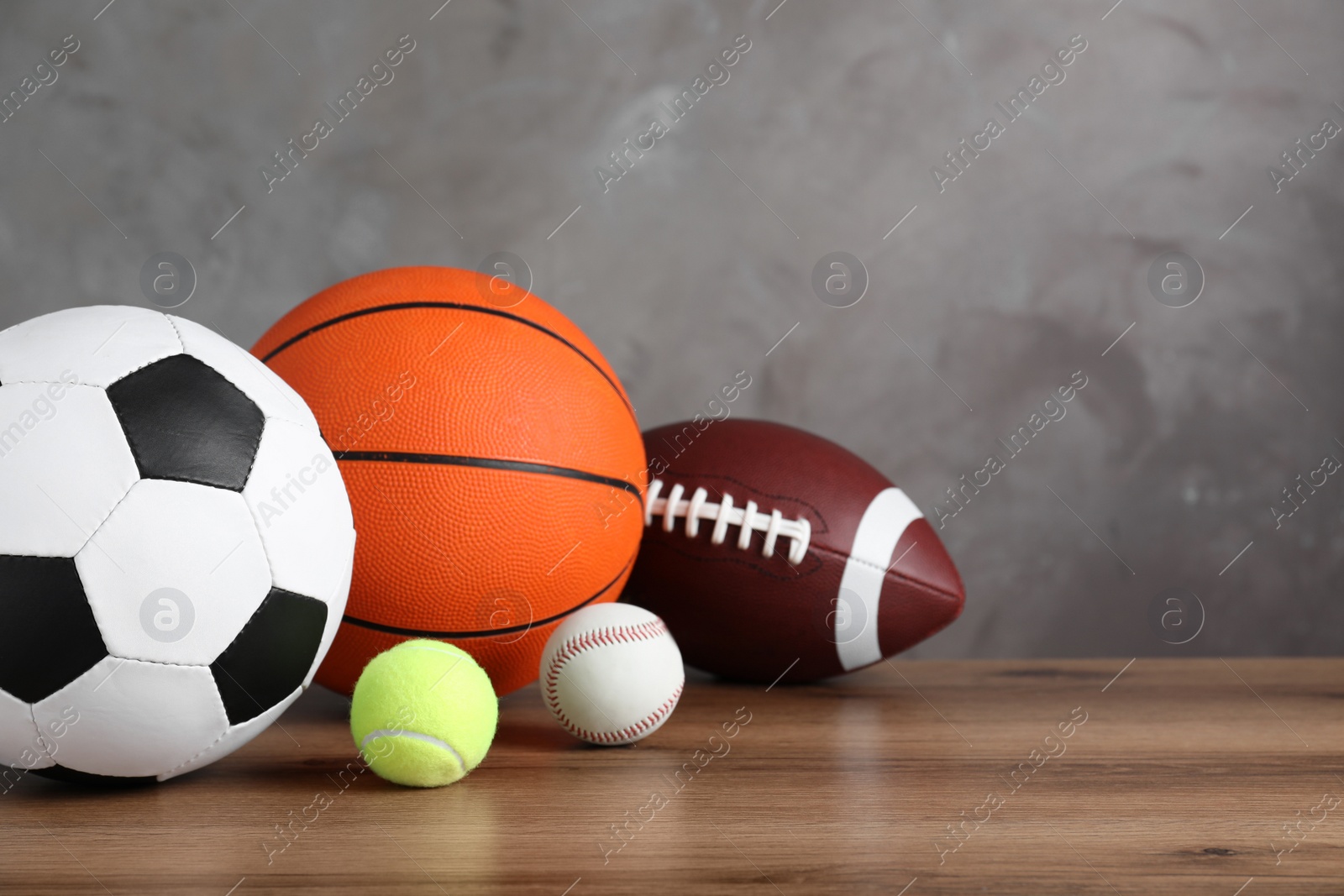 Photo of Set of different sport balls on wooden surface. Space for text