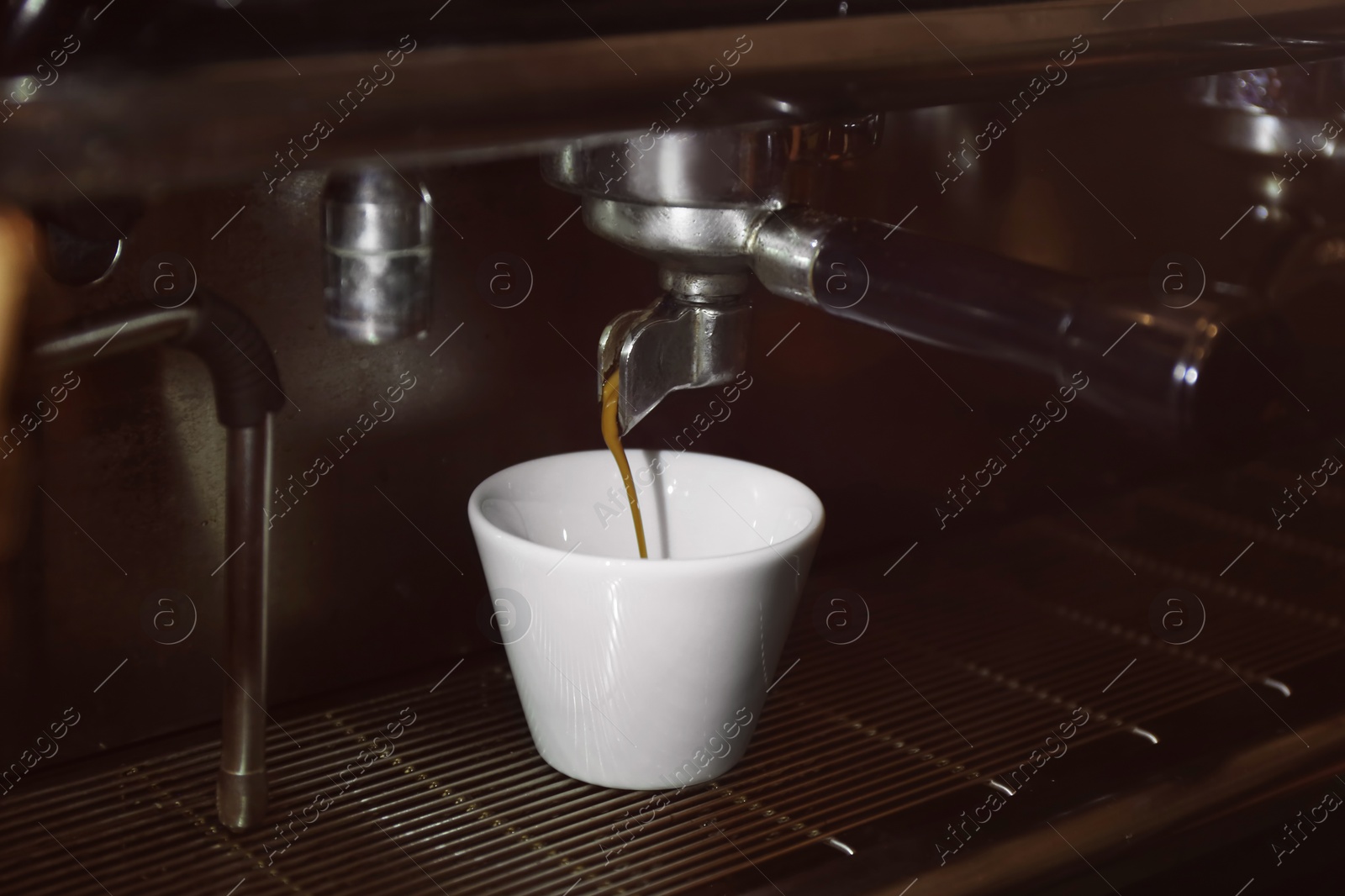 Photo of Preparing fresh aromatic coffee on modern machine, closeup