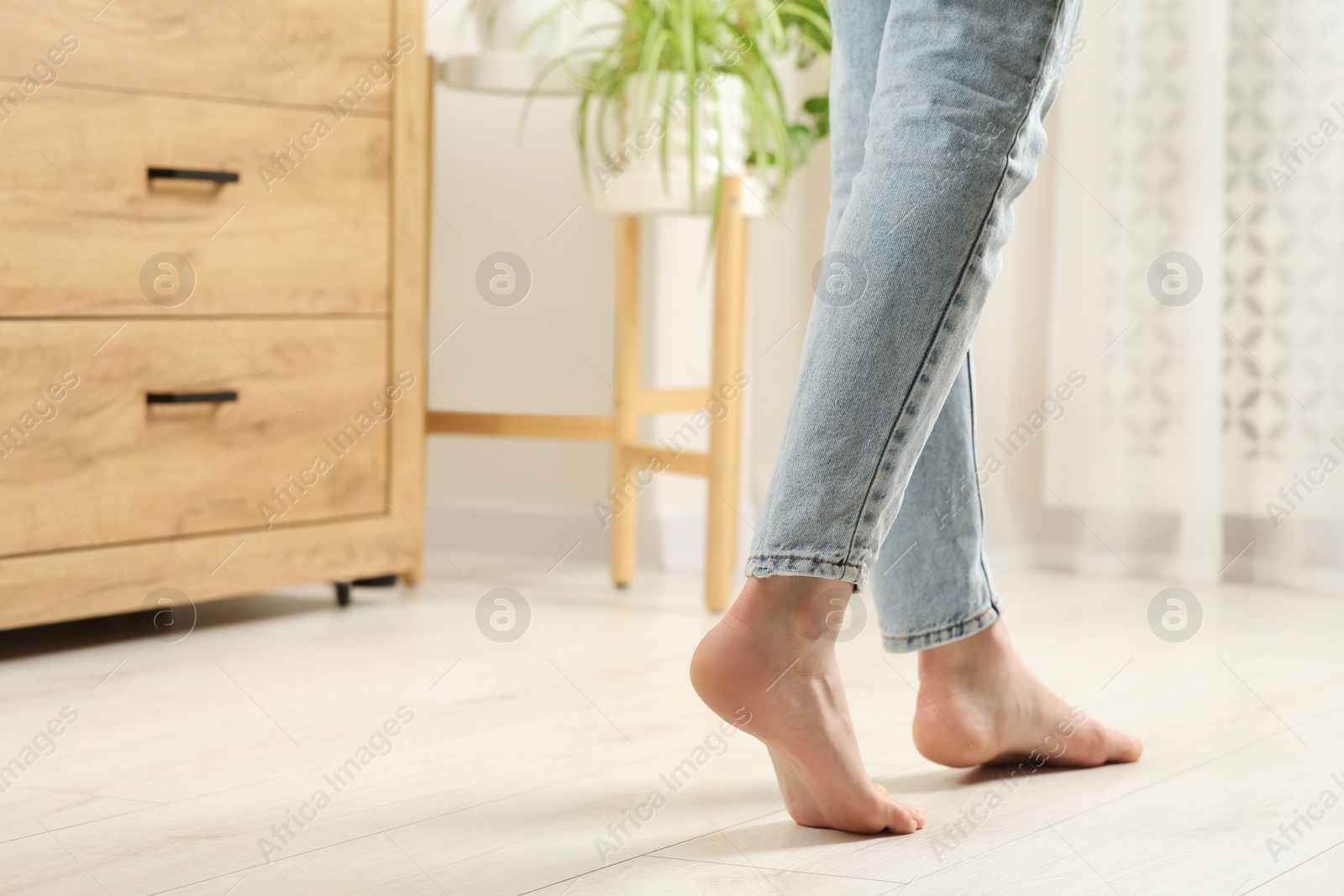 Photo of Woman stepping barefoot in room at home, closeup with space for text. Floor heating