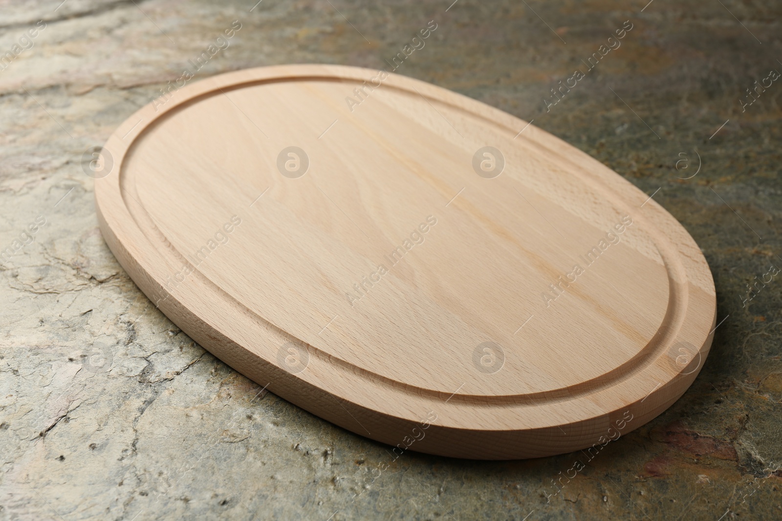 Photo of Wooden cutting board on textured table, closeup