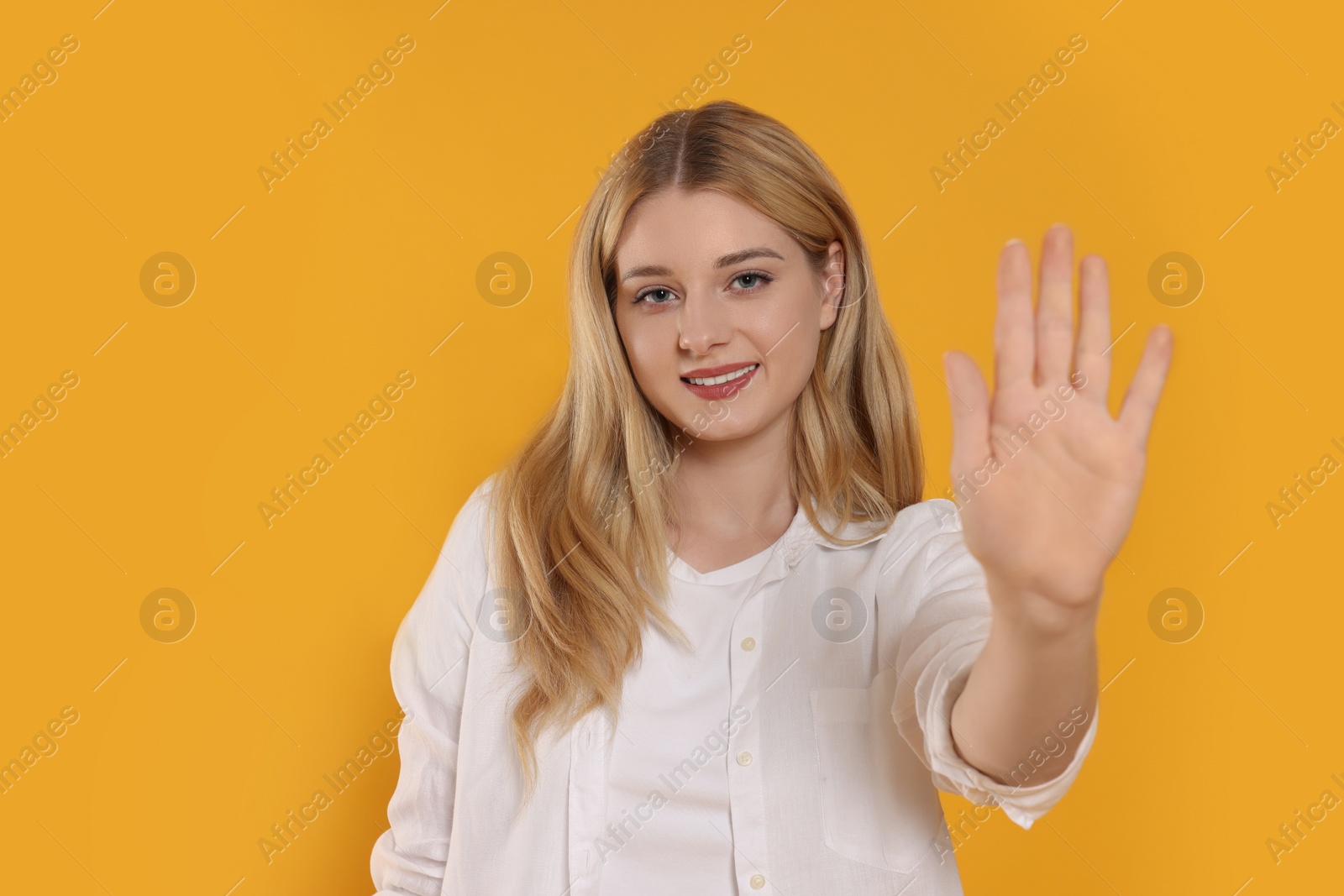 Photo of Happy woman giving high five on orange background