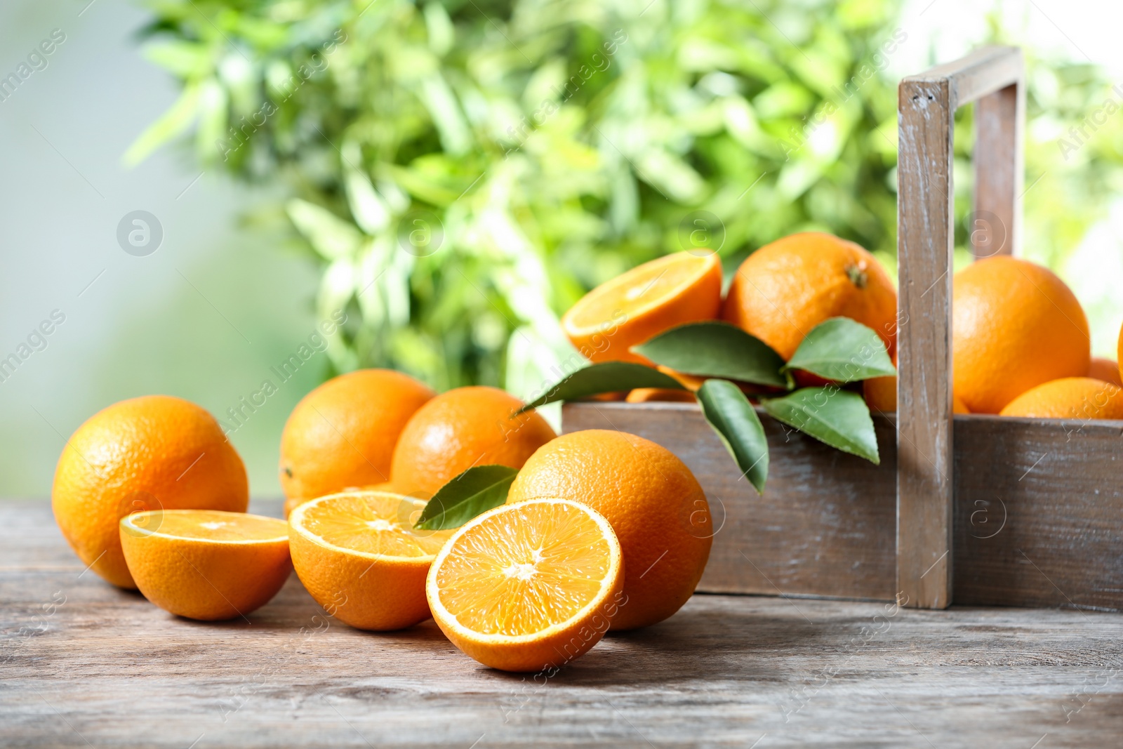 Photo of Ripe oranges on table against blurred background. Space for text