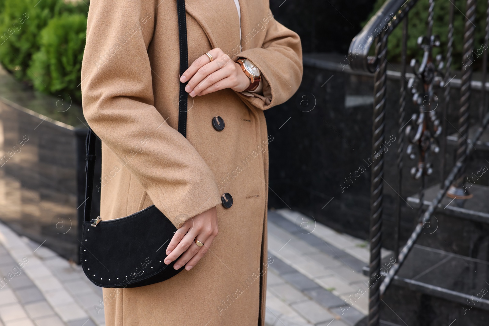 Photo of Fashionable woman with stylish bag on city street, closeup. Space for text