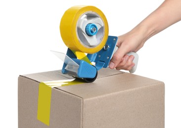 Photo of Woman applying adhesive tape on box with dispenser against white background, closeup