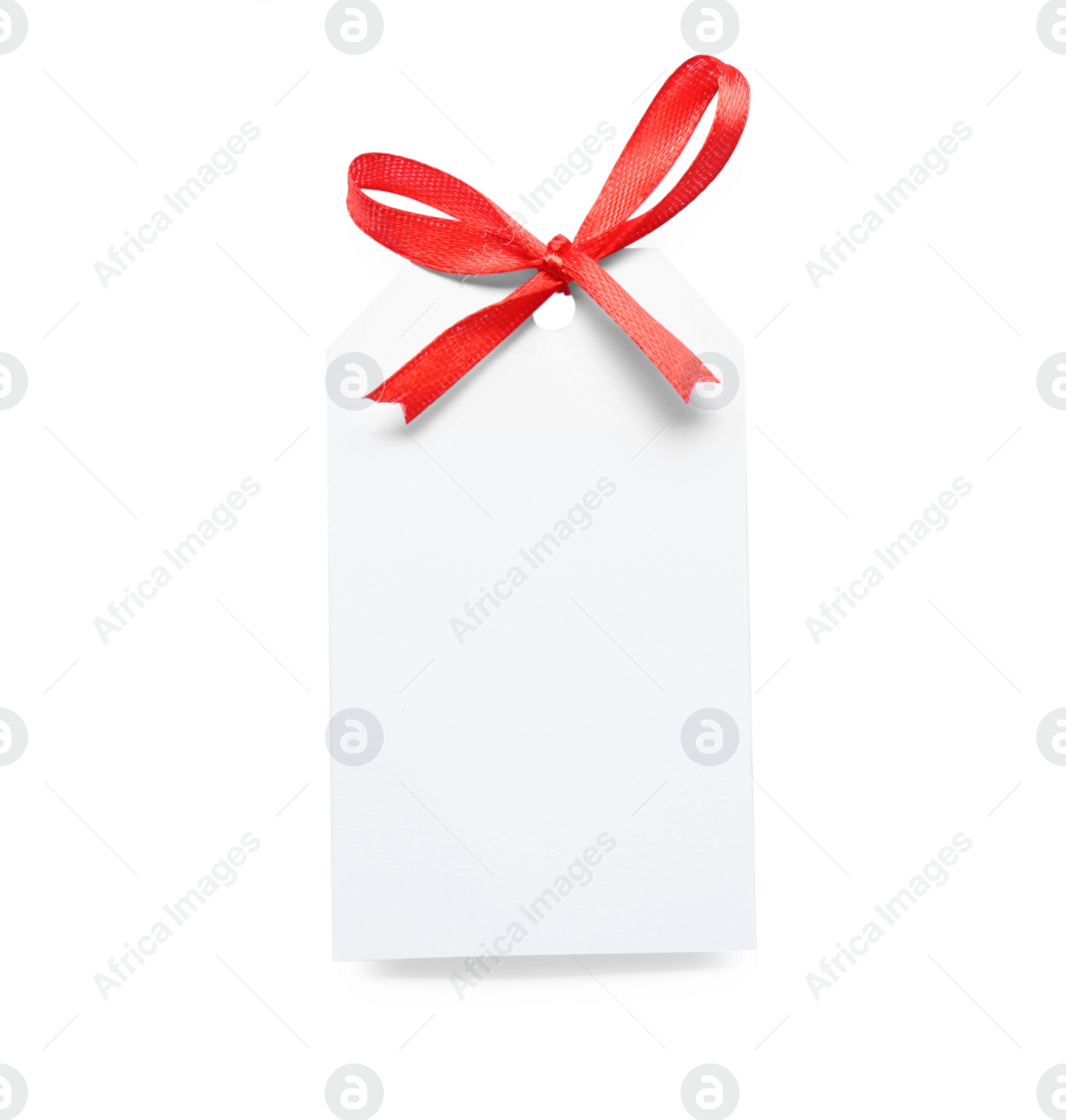 Photo of Blank gift tag with red satin ribbon on white background, top view