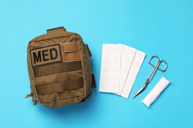 Photo of Military first aid kit on light blue background, flat lay
