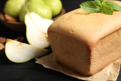 Tasty pear bread and mint on black table, closeup. Homemade cake