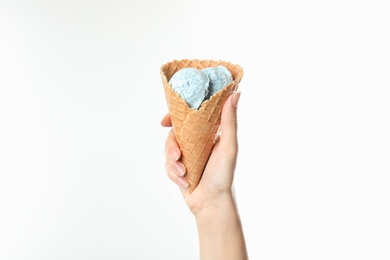 Photo of Woman holding delicious ice cream in waffle cone on white background, closeup