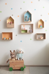 Photo of Stylish baby room interior design with house shaped shelves