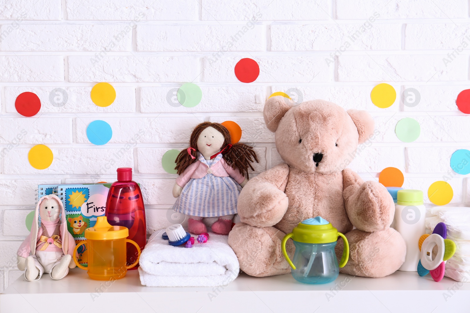 Photo of Baby accessories on shelf near white brick wall