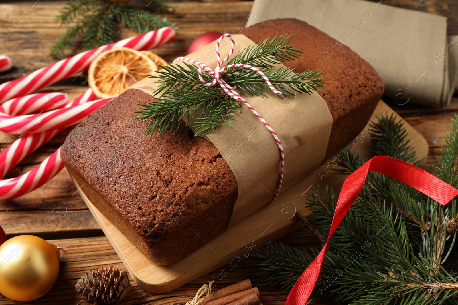 Photo of Delicious gingerbread cake, candy canes and Christmas decor on wooden table