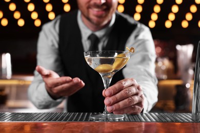 Photo of Bartender with fresh alcoholic cocktail in bar, closeup