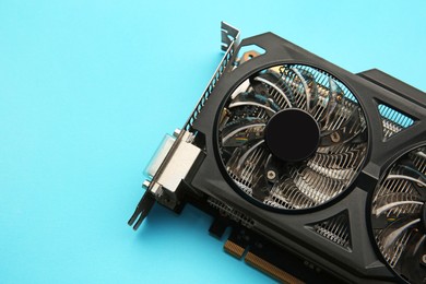 Photo of One graphics card on light blue background, top view. Space for text