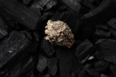 Photo of Shiny gold nugget on coals, top view