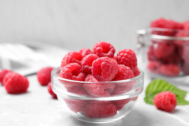 Photo of Delicious fresh ripe raspberries on light grey table