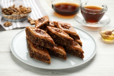 Delicious sweet baklava with walnuts on white wooden table, closeup