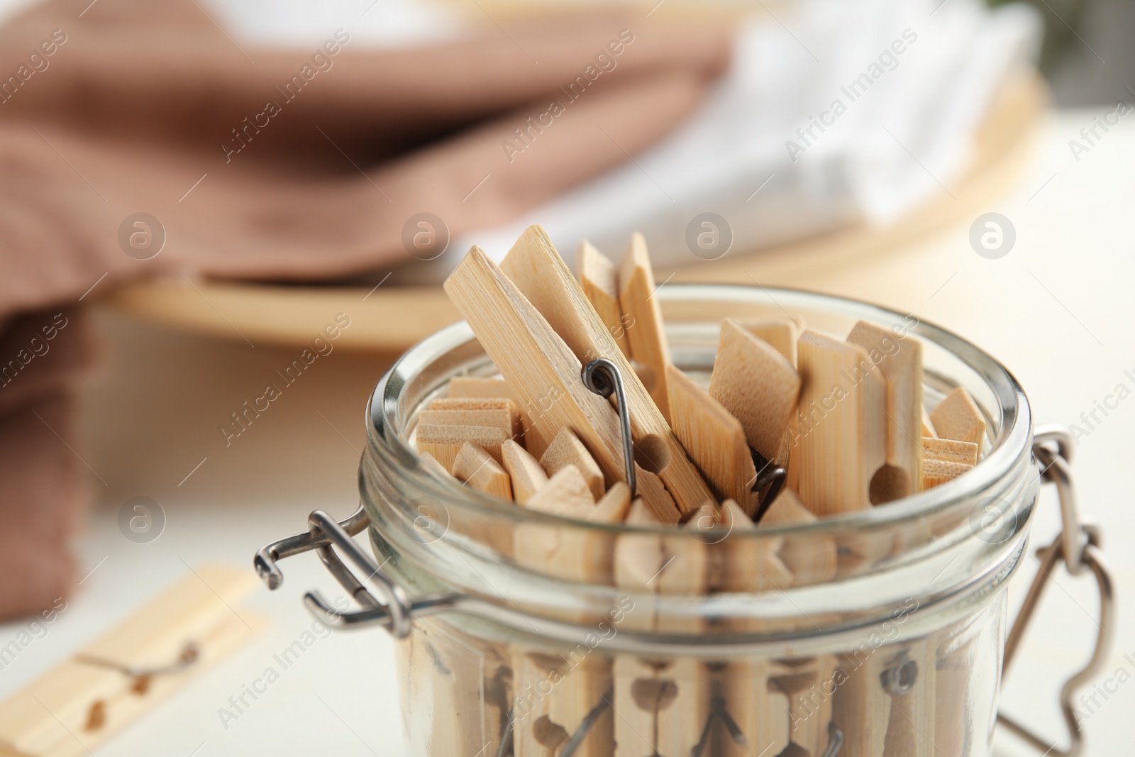 Photo of Many wooden clothespins in glass jar, closeup