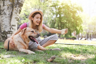 Photo of Young woman taking selfie with her dog outdoors. Pet care