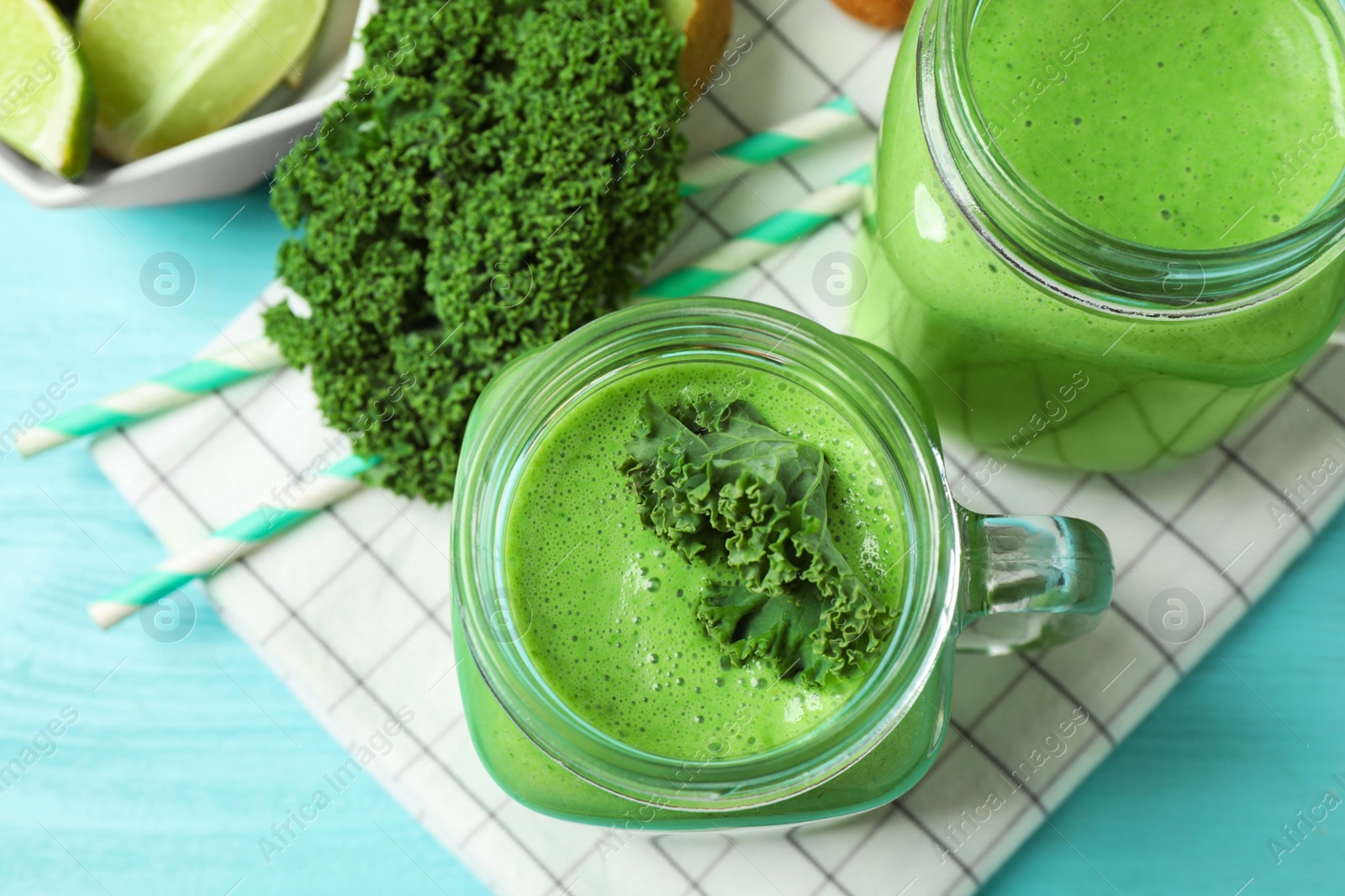 Photo of Tasty fresh kale smoothie on light blue table, flat lay