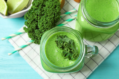 Photo of Tasty fresh kale smoothie on light blue table, flat lay