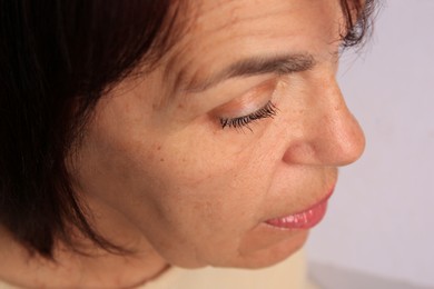Photo of Skin care. Senior woman on blurred background, closeup
