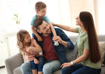 Photo of Young happy family with children at home