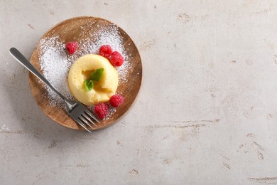 Tasty vanilla fondant with white chocolate and raspberries on light grey table, top view. Space for text