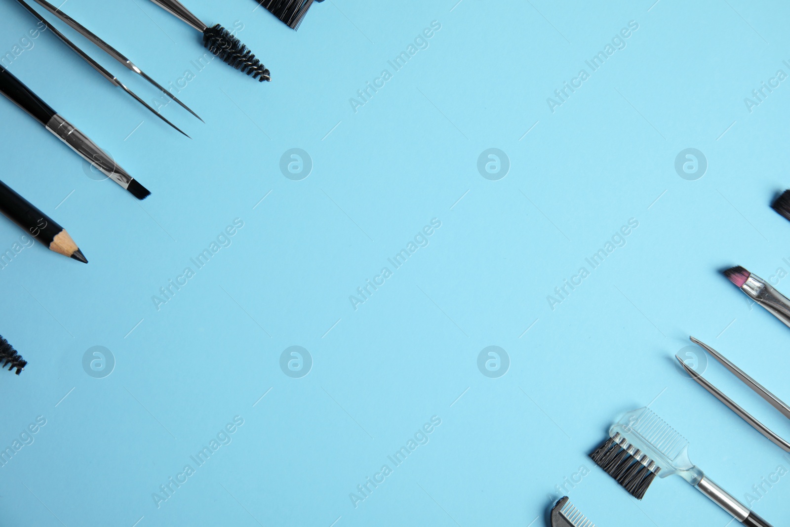 Photo of Set of professional eyebrow tools on blue background, flat lay. Space for text