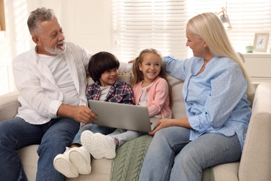 Photo of Happy grandparents spending time with grandchildren at home