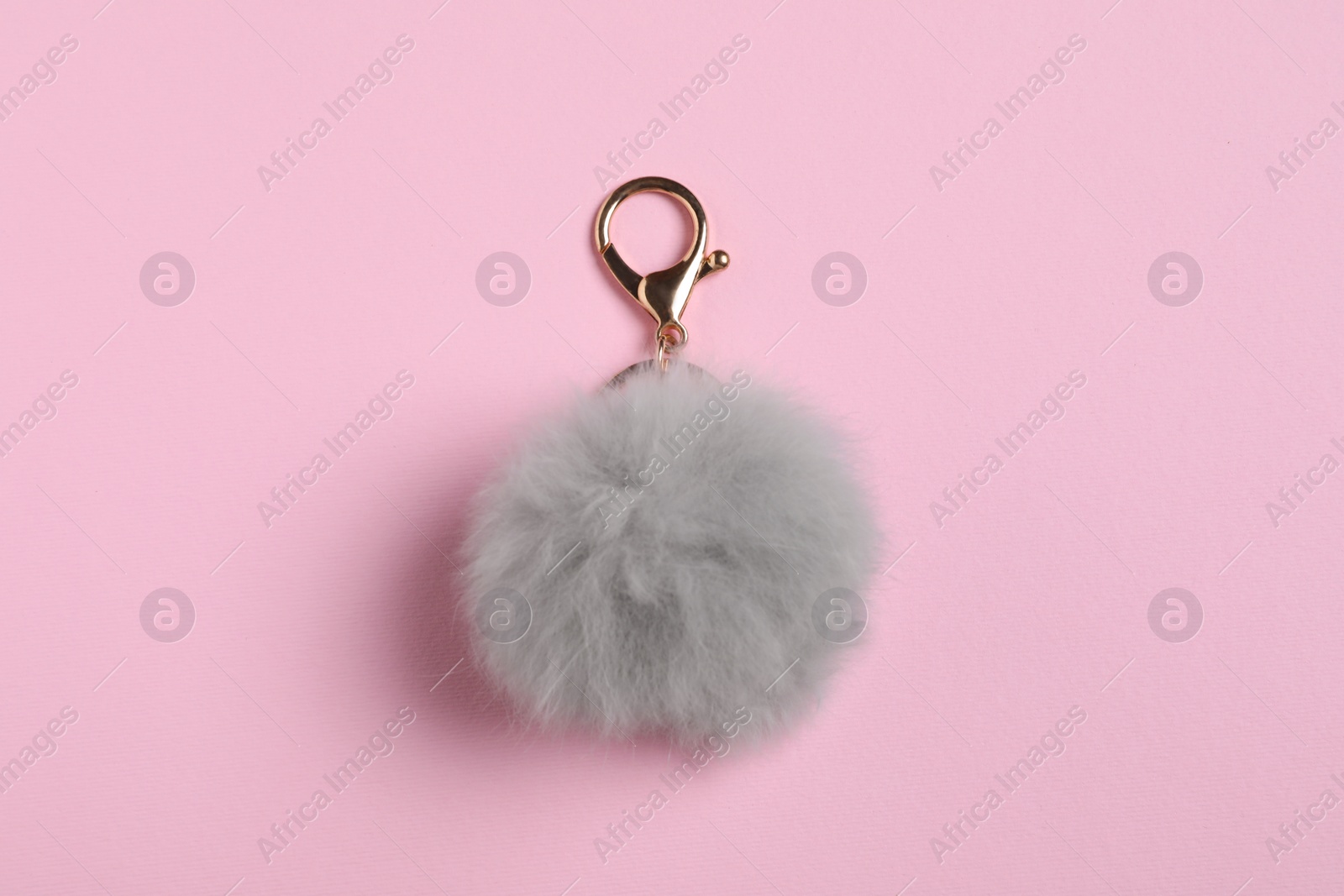 Photo of Gray fur keychain on pale pink background, top view