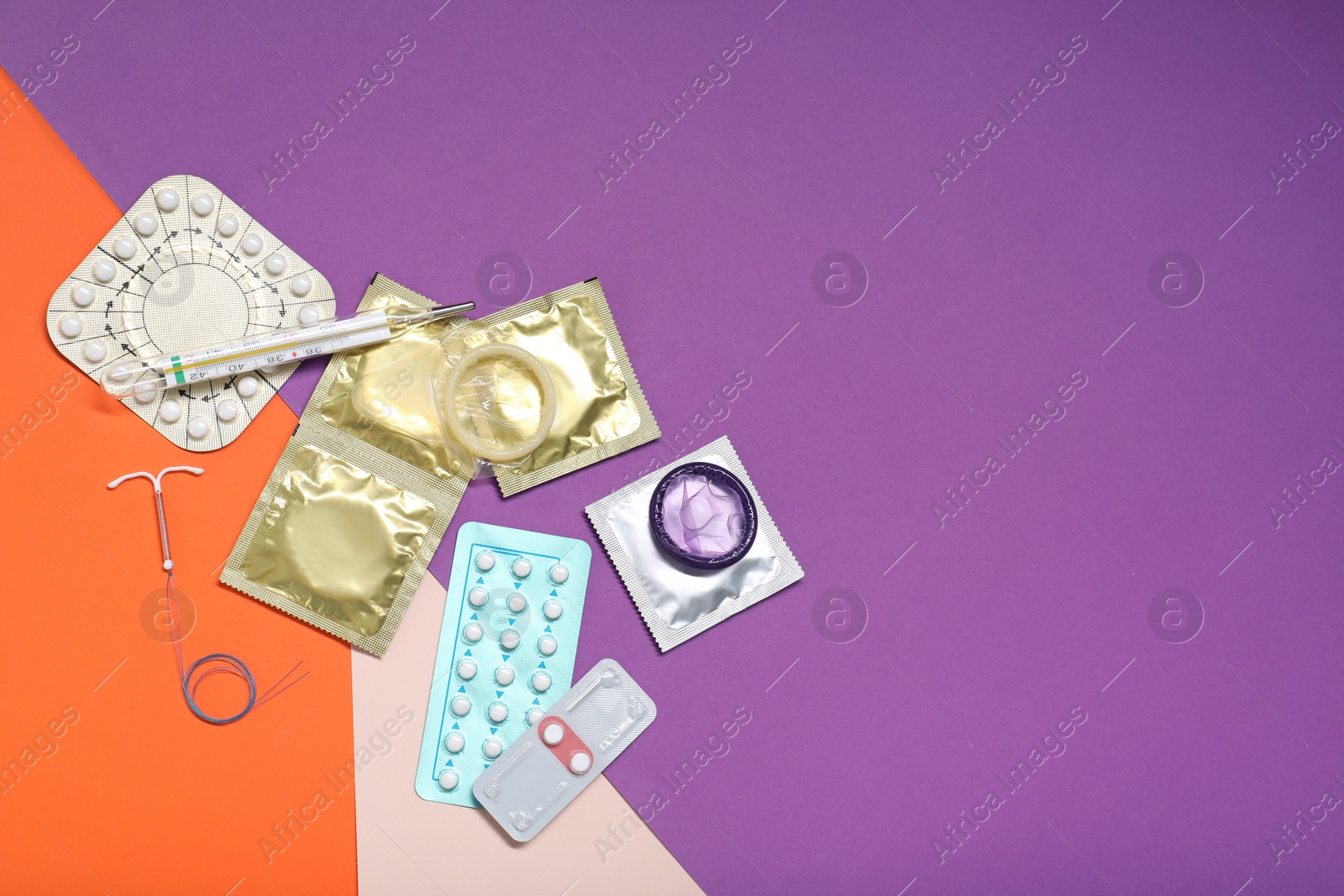 Photo of Contraceptive pills, condoms, intrauterine device and thermometer on color background, flat lay with space for text. Choice of birth control method