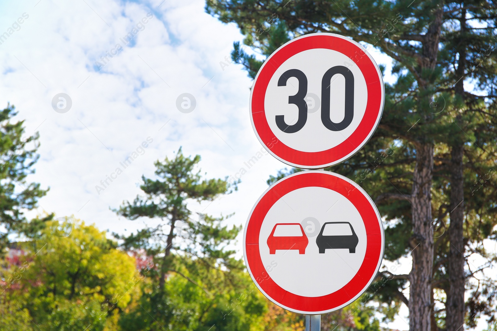 Photo of Post with road signs Maximum Speed 30 and No Overtaking outdoors. Space for text